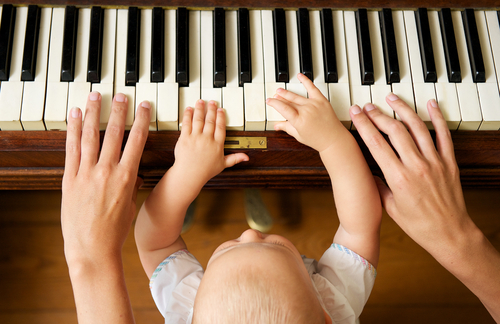 Baby Plays Piano with Parent
