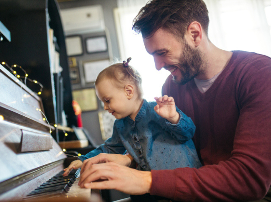 baby playing piano with dad