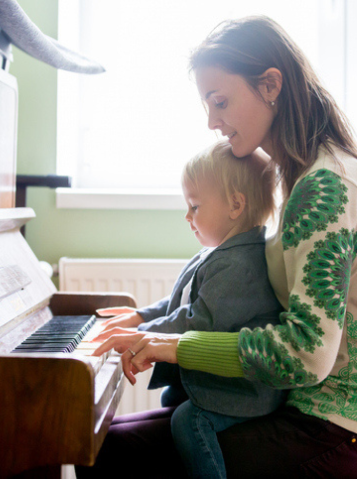 mom playing piano with baby