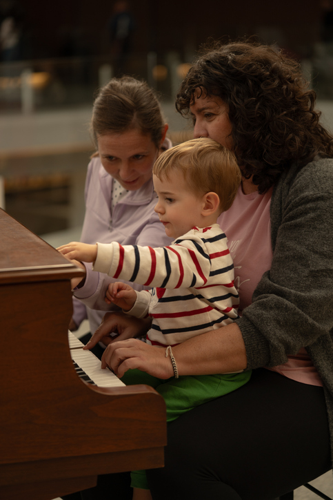 a couple of two women and their son playing the piano