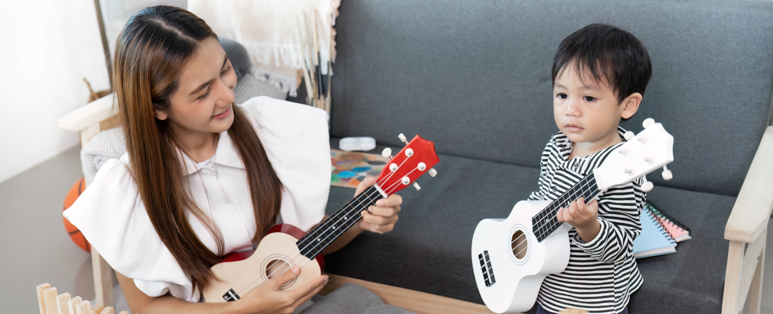 mom and toddler playing guitar together