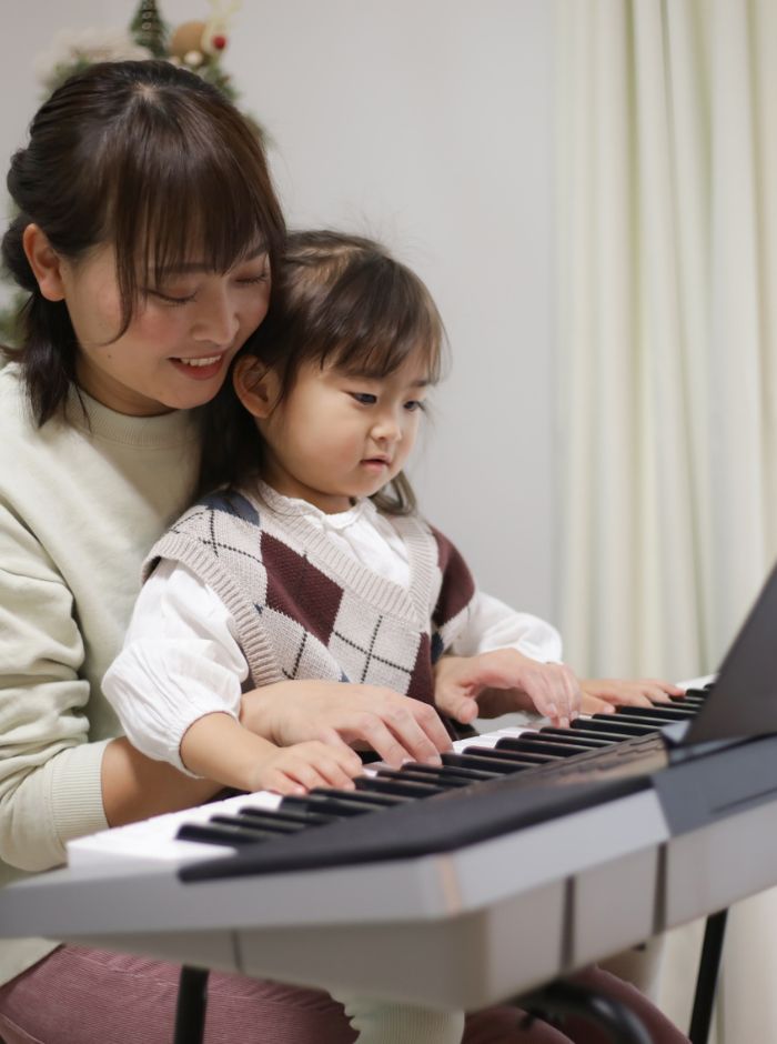 mom and toddler playing piano